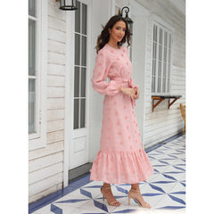 Fashionable women's dress with long sleeves and a large fluffy pom-pom detail, made from chiffon fabric
