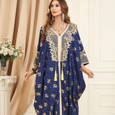 ارتقي بأناقتك مع الجلابية المزينة بالفويل الذهبي، والتي تتميز بزخارف مطرزة، وخط عنق على شكل حرف V أنيق وشرابات مرحة