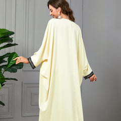 استمتعي بسحر الجلابية مع زخارف مطرزة، وزخرفة من الدانتيل الرقيق على الأساور، ولمسات شرابة، وأكمام فضفاضة على شكل جناح الخفاش