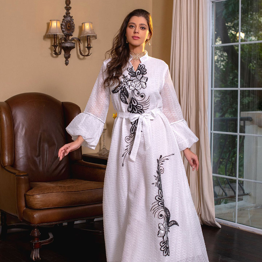 Jalabiya Elevate your style with a fashionable and avant-garde jalabiya | featuring embroidered appliques | bell sleeves | a waist-cinching tie | and a contemporary edge