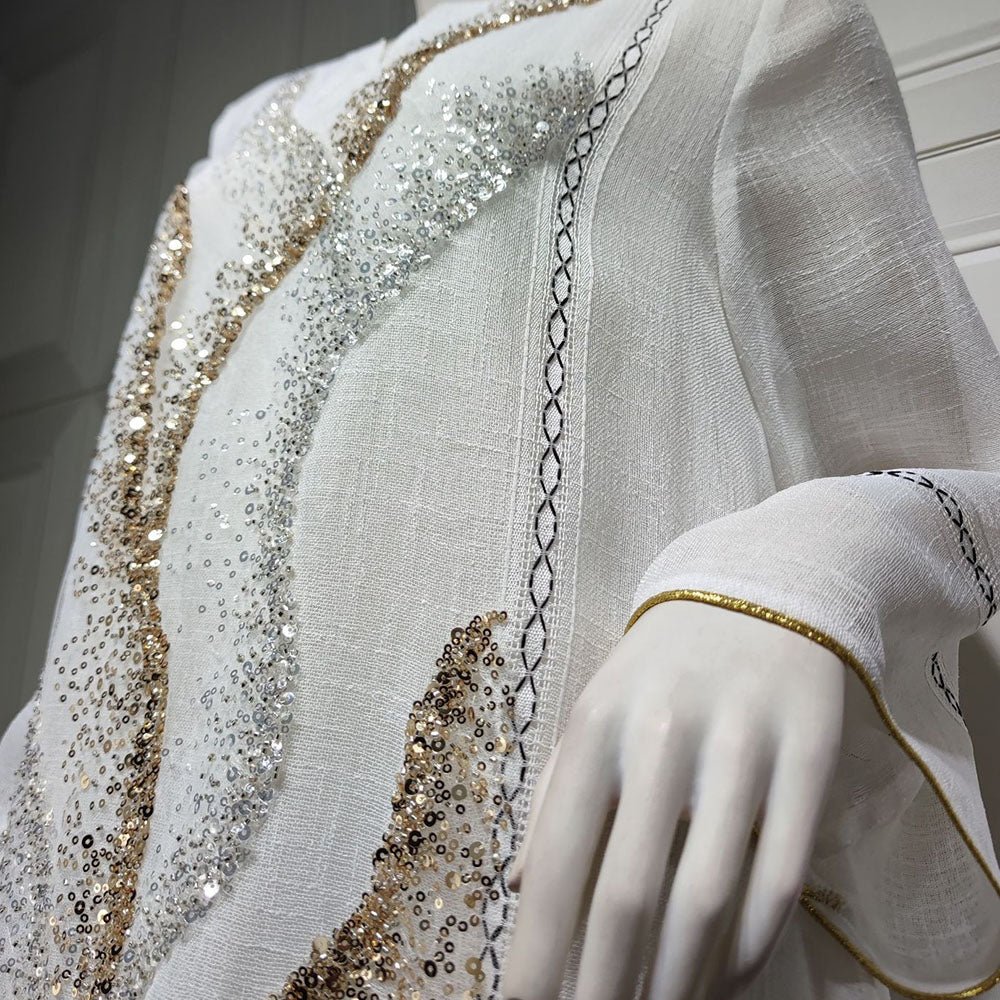 Indulge in the exquisite elegance of a white mesh jalabiya, adorned with beadwork embroidery, offering a lightweight and luxurious comfort