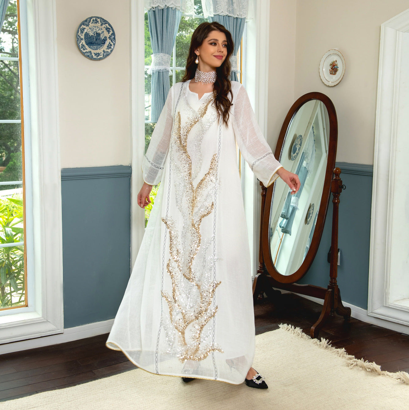 Indulge in the exquisite elegance of a white mesh jalabiya, adorned with beadwork embroidery, offering a lightweight and luxurious comfort